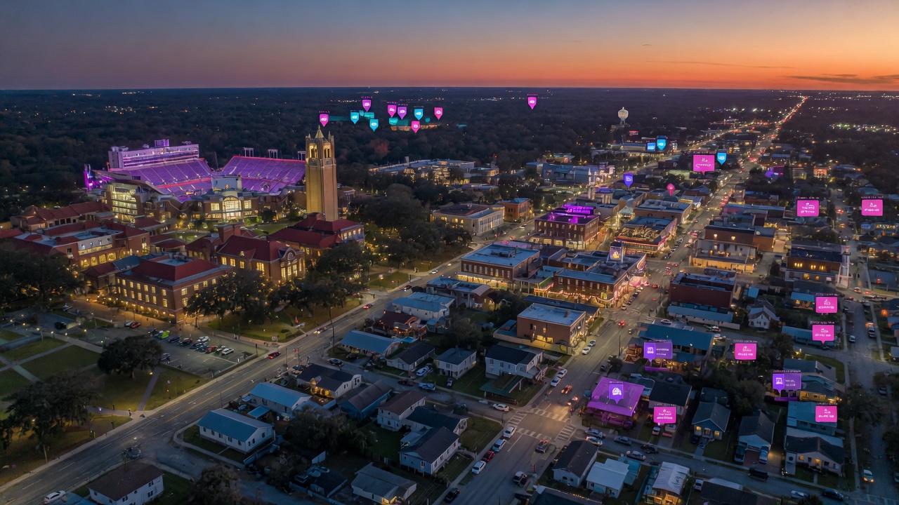 Ultra-realistic 8K aerial view of Gainesville Florida at dusk showing the University of Florida campus, downtown area, and surrounding residential neighborhoods with short-term rentals highlighted