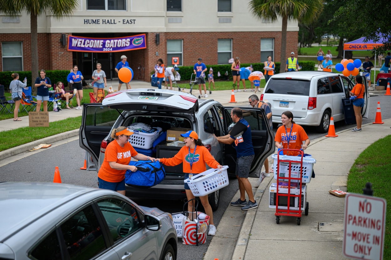 University of Florida student move-in day scene showing busy parents and students unloading cars near campus housing, illustrating seasonal rental demand spikes