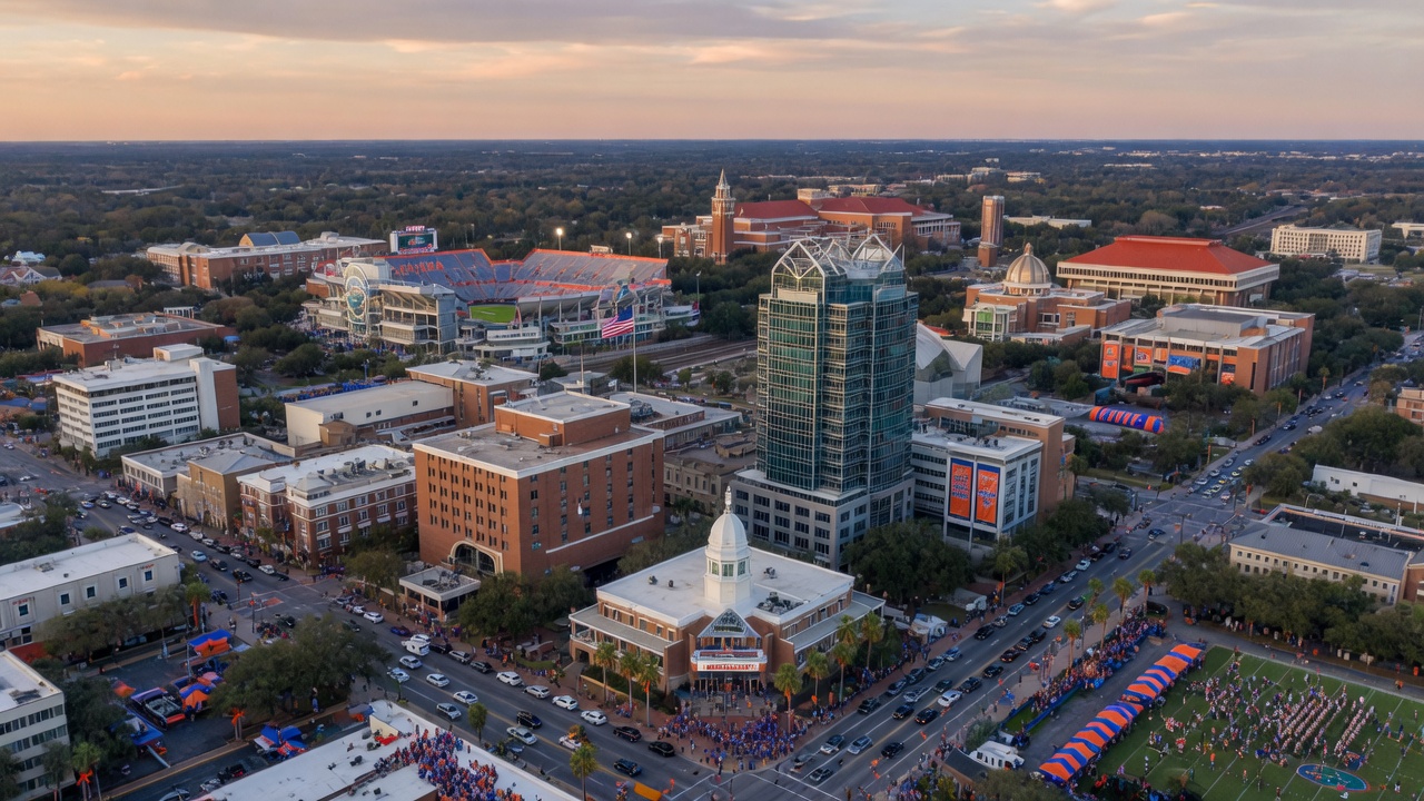 Aerial view of downtown Gainesville Florida skyline with University of Florida buildings visible in distance during football season, 8K resolution